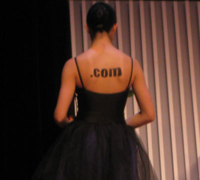 Espalda de otra de las bailarinas con el texto .com dibujado